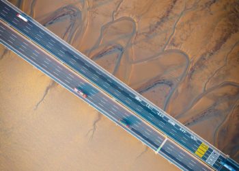 An aerial view of a bridge over mudflats.