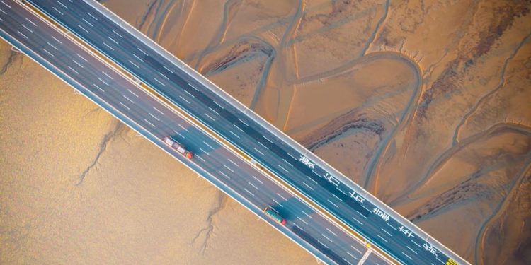 An aerial view of a bridge over mudflats.