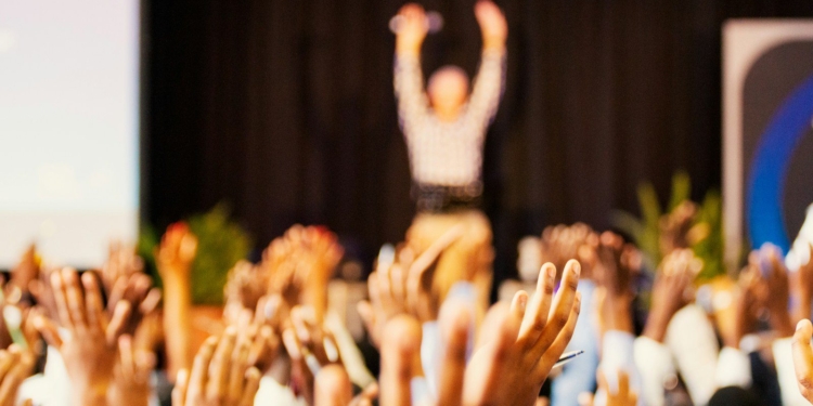 people raising hands with bokeh lights