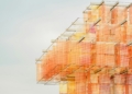 Abstract building with orange and pink hues.