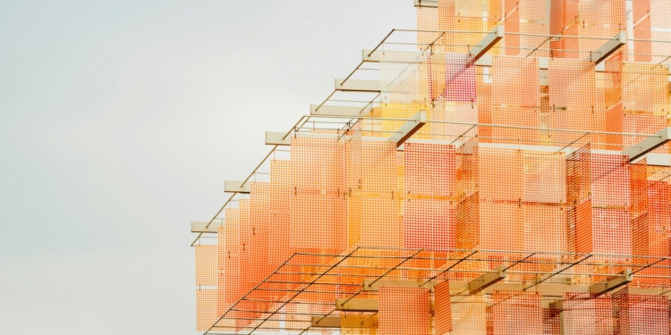 Abstract building with orange and pink hues.
