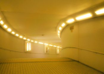 A yellow lit tunnel with windows.