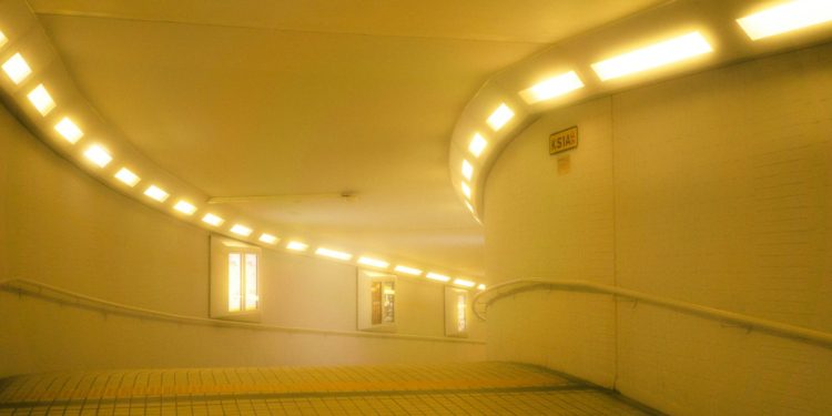 A yellow lit tunnel with windows.