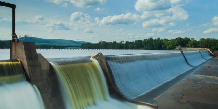 water dam under white and blue skies