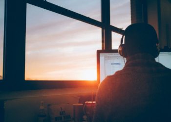 man sitting facing monitor