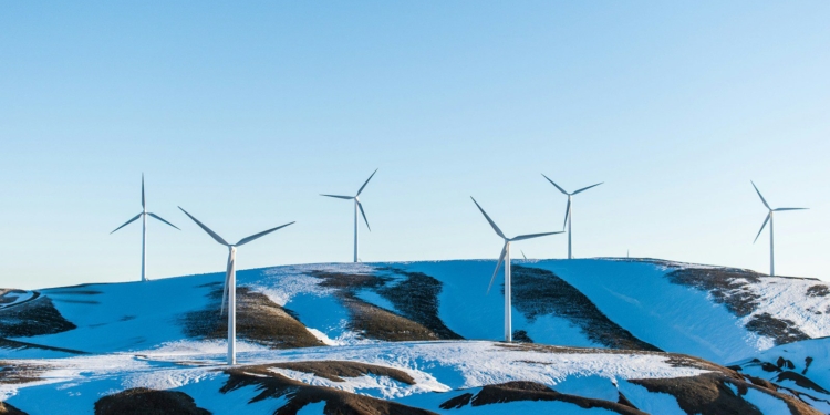 windmills surrounded by snow-covered field during daytime