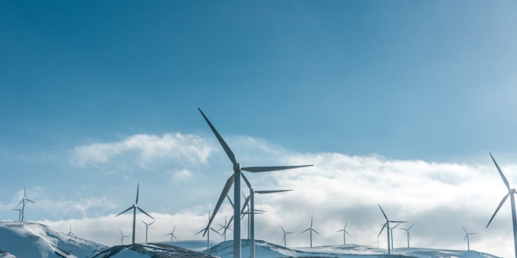 wind turbines on snowy mountain under clear blue sky during daytime