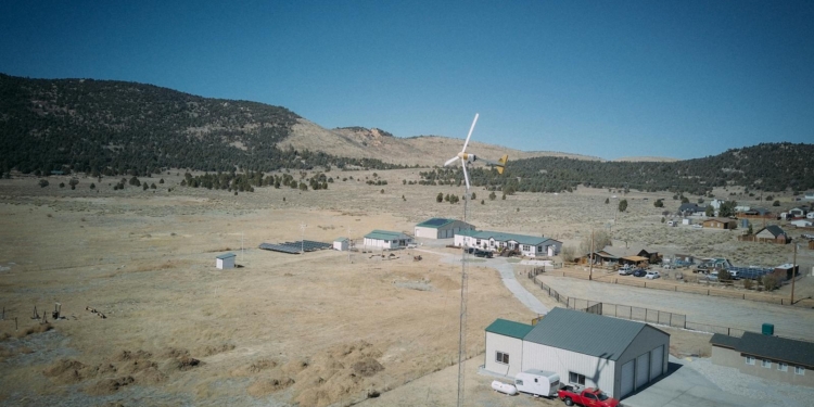 Aerial view capturing a wind turbine in a rural landscape, showcasing sustainable energy.