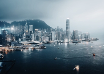 Hong kong cityscape glows at night by the sea.