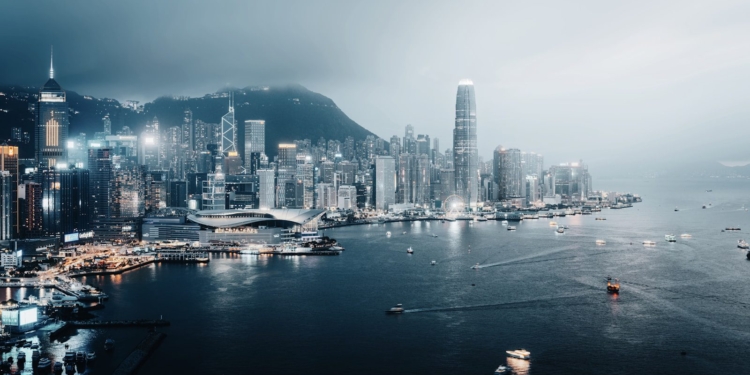 Hong kong cityscape glows at night by the sea.