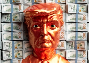 A golden trump head stands before stacks of money.
