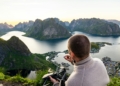 Man painting a scenic norwegian fjord landscape from above