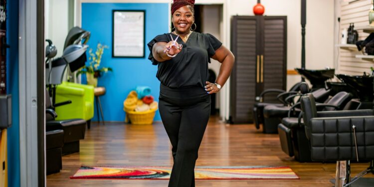 Woman in salon gives peace sign towards camera