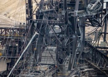 there is a large crane that is in the dirt