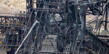 there is a large crane that is in the dirt