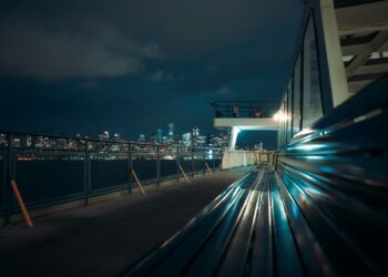 City skyline at night seen from a ferry deck.