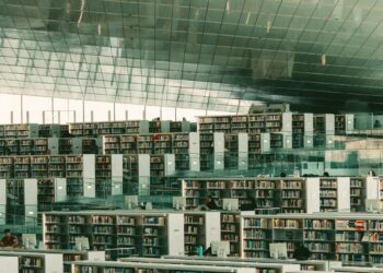 Modern library with expansive bookshelves and seating areas.