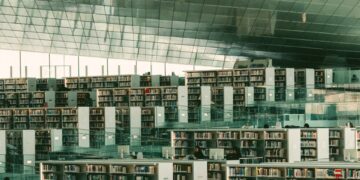 Modern library with expansive bookshelves and seating areas.