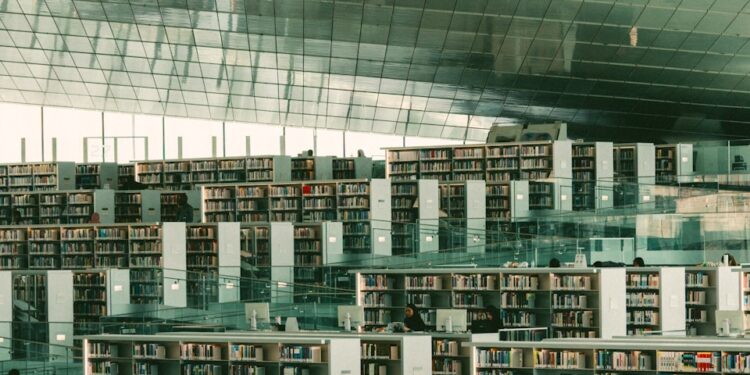 Modern library with expansive bookshelves and seating areas.