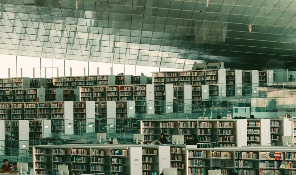 Modern library with expansive bookshelves and seating areas.