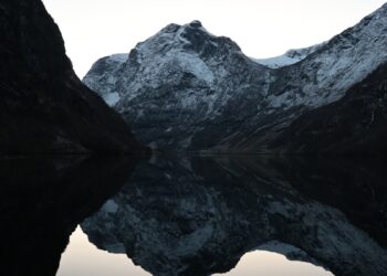 Snow-capped mountains reflected in calm water